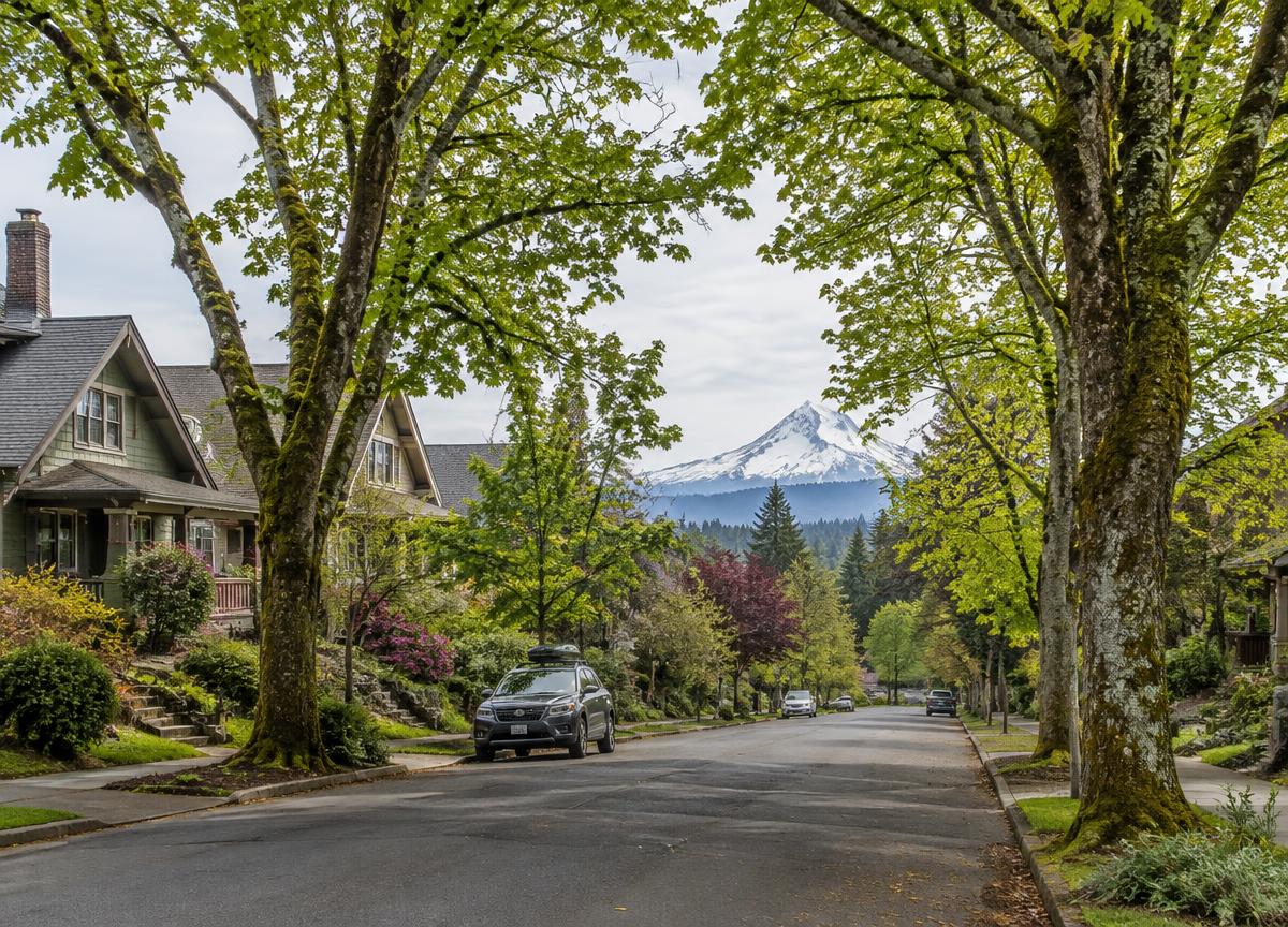 Illustrative tree-lined Oregon residential street with a Cascade peak beyond
